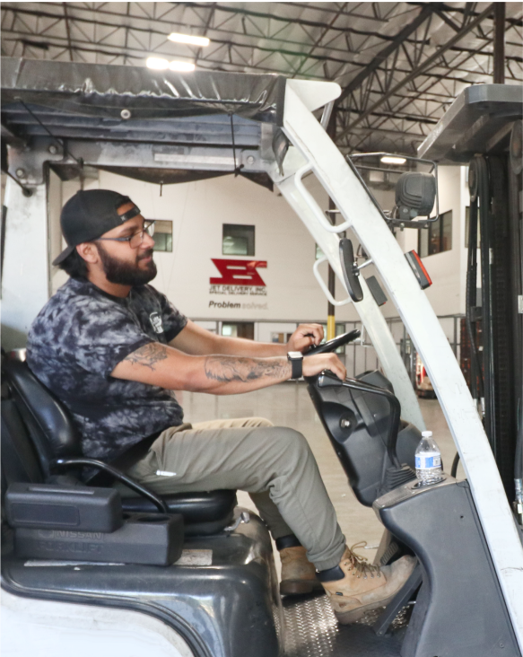 Warehouse worker driving a forklift at Jet Delivery's facility